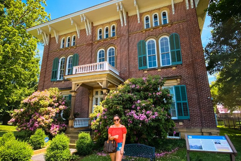 A woman stands outside Henderson Hall in the spring time.