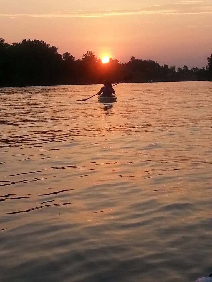 Kayaking on a river with sun setting
