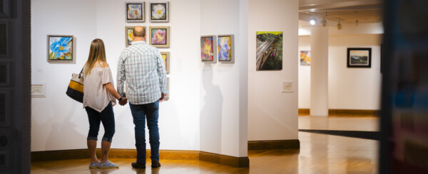 A golden age couple at the Parkersburg Art Center admiring a gallery.