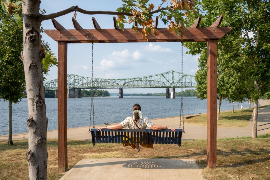 A woman sits on a swing at Point Park in downtown Parkersburg, WV
