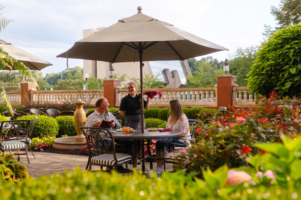 A waitress serves a couple eating outside at the Blennerhassett Hotel's patio in downtown Parkersburg, WV.